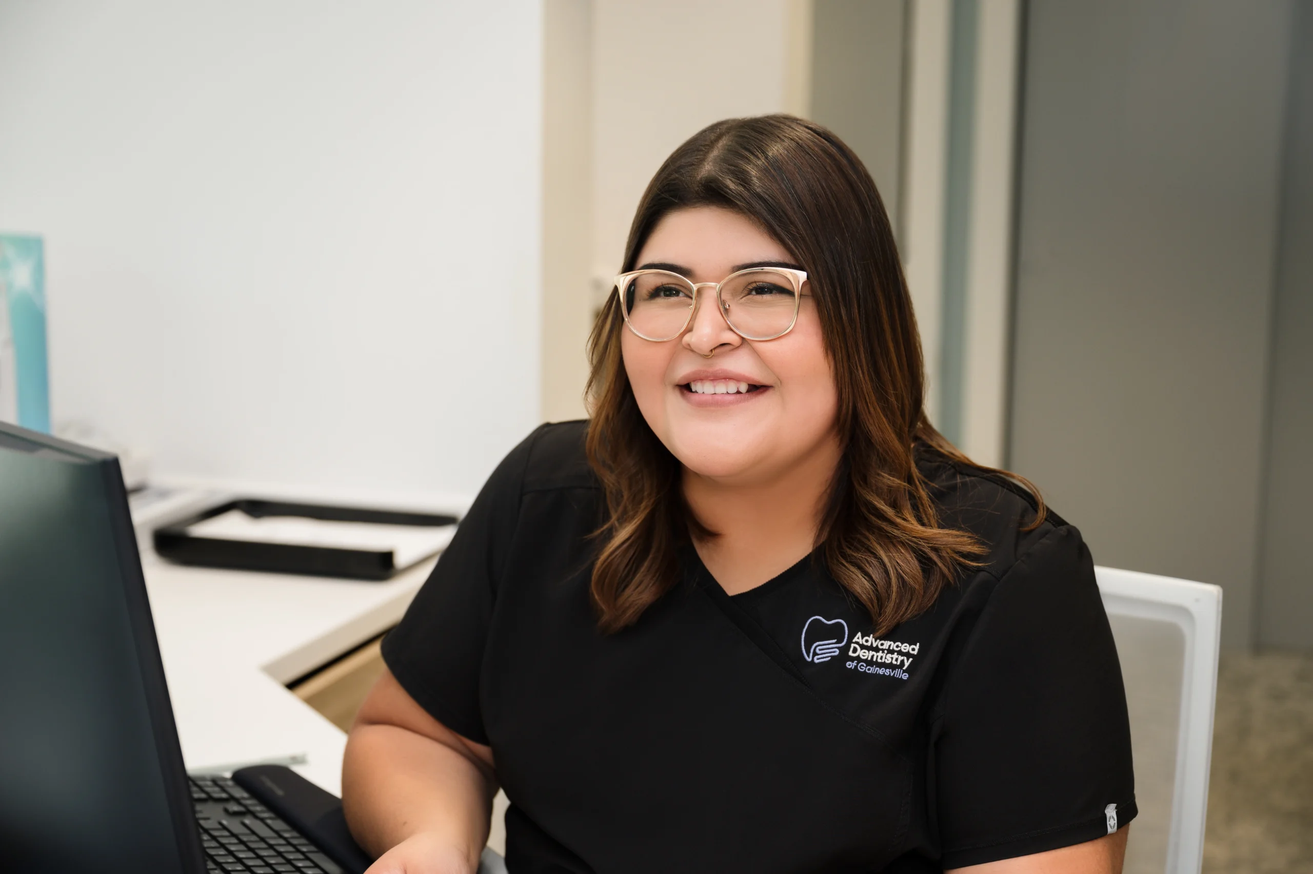 Maria looking up from a computer workstation and smiling