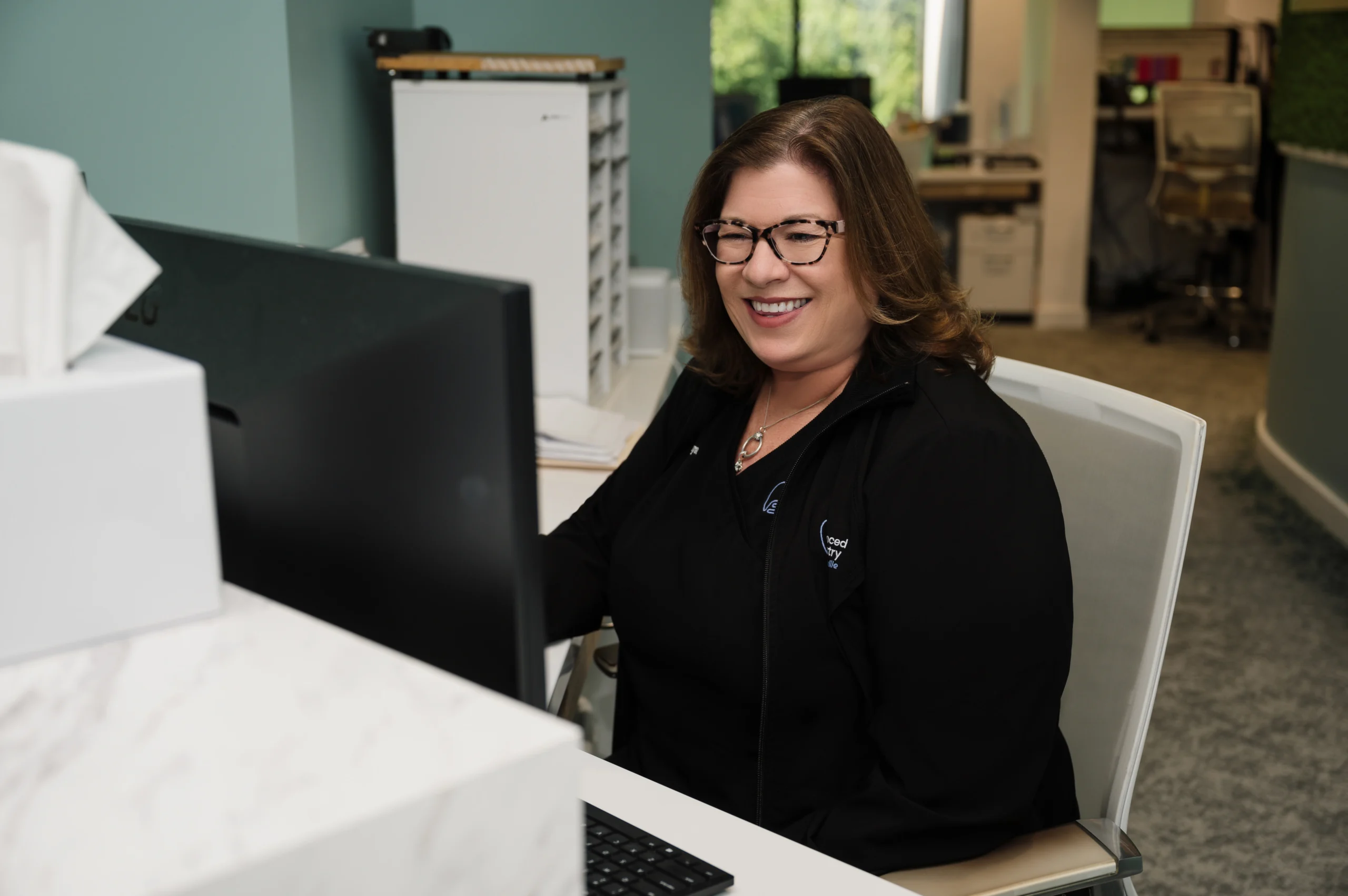 Tonya working at a computer smiling