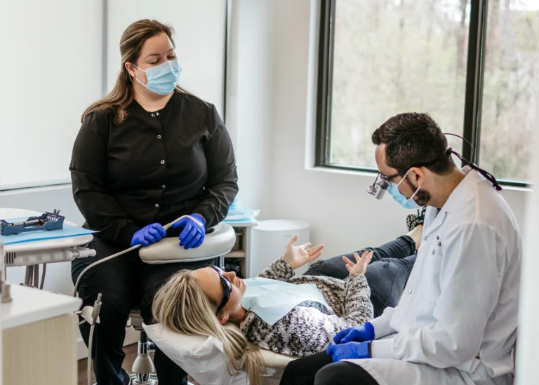 Seated around a patient, staff at Advanced Dentistry of Gainesville listen to a patient's concerns during their cleaning to better understand their needs.