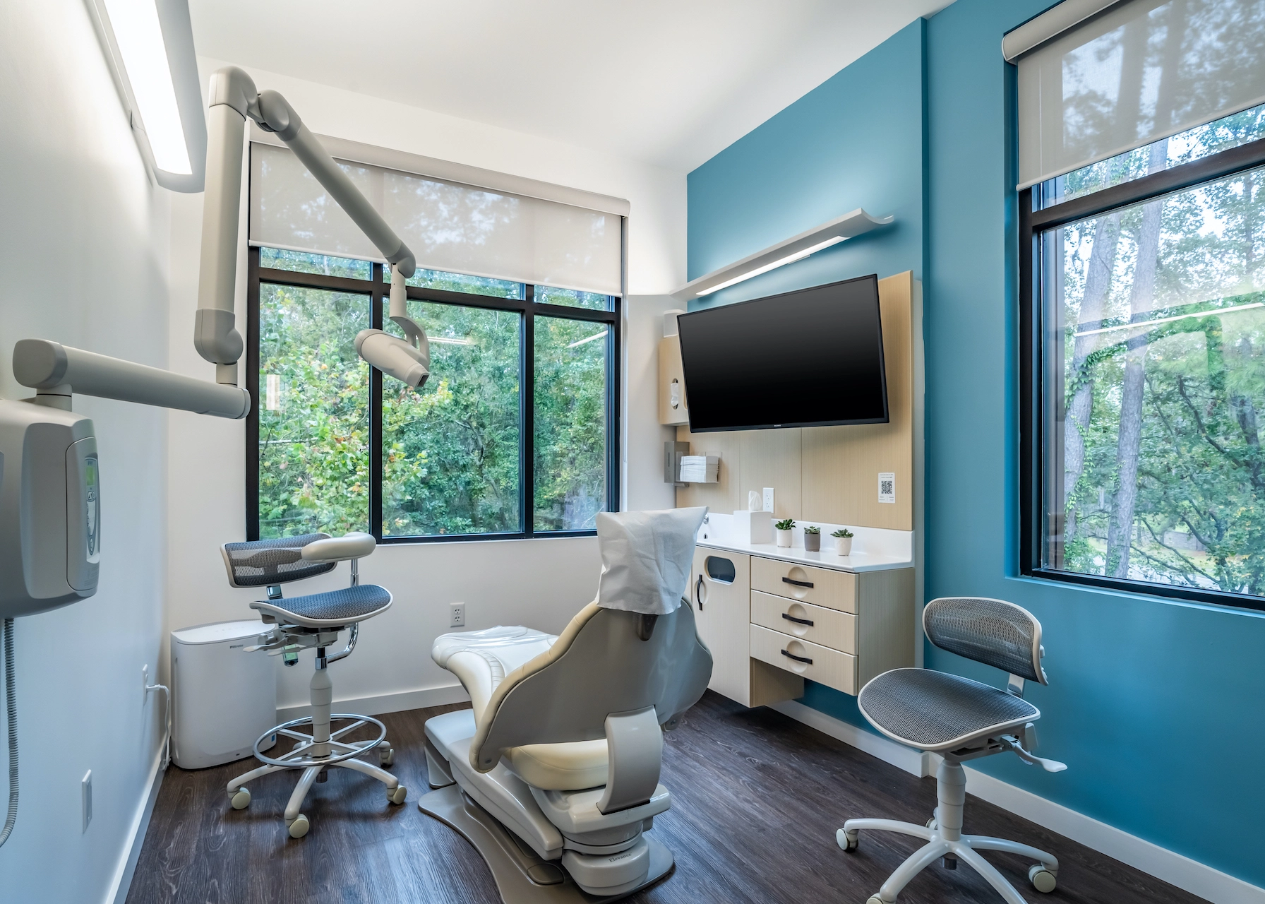A patient room at Advanced Dentistry of Gainesville, overlooking a calming forest and filled with the latest dental tech.
