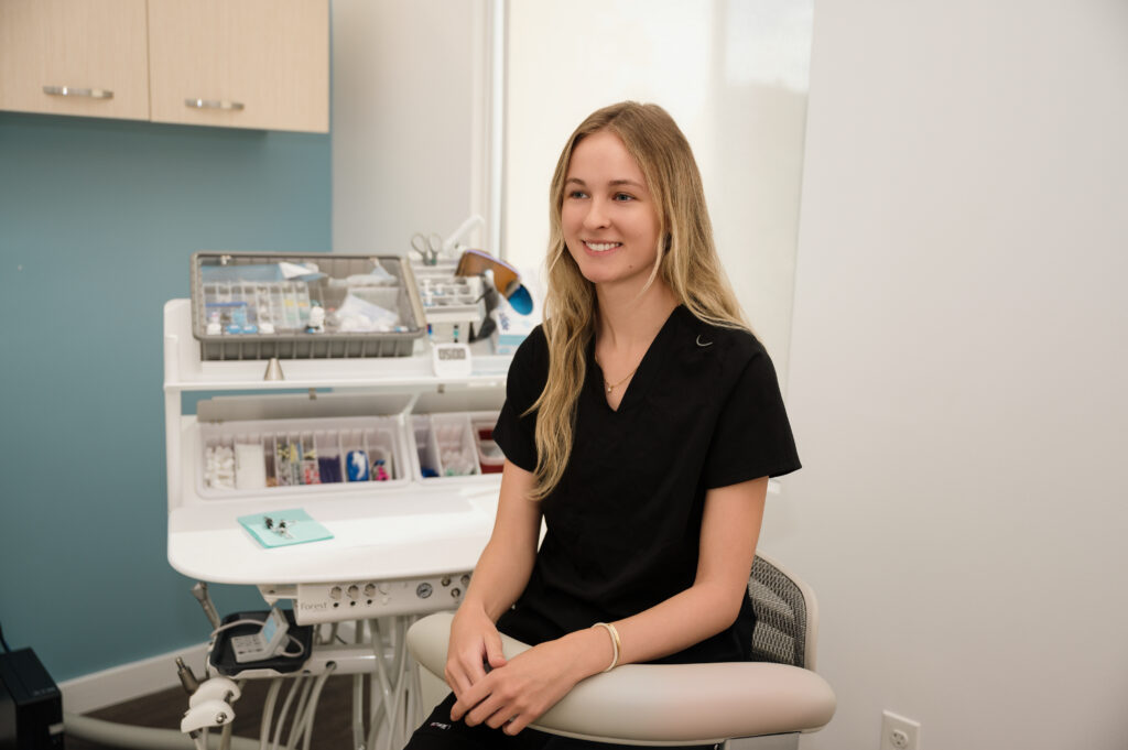 Stephanie sitting next to an exam table smiling